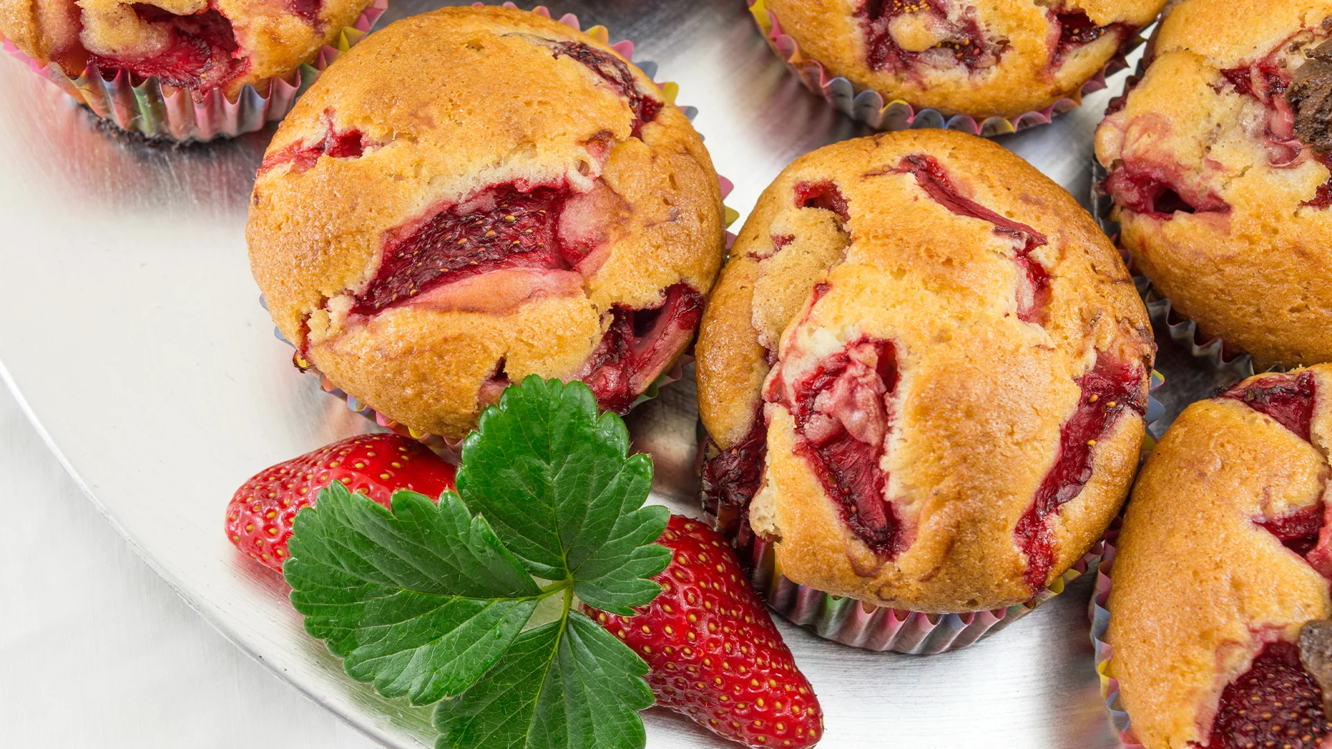 Strawberry muffins on a white plate.