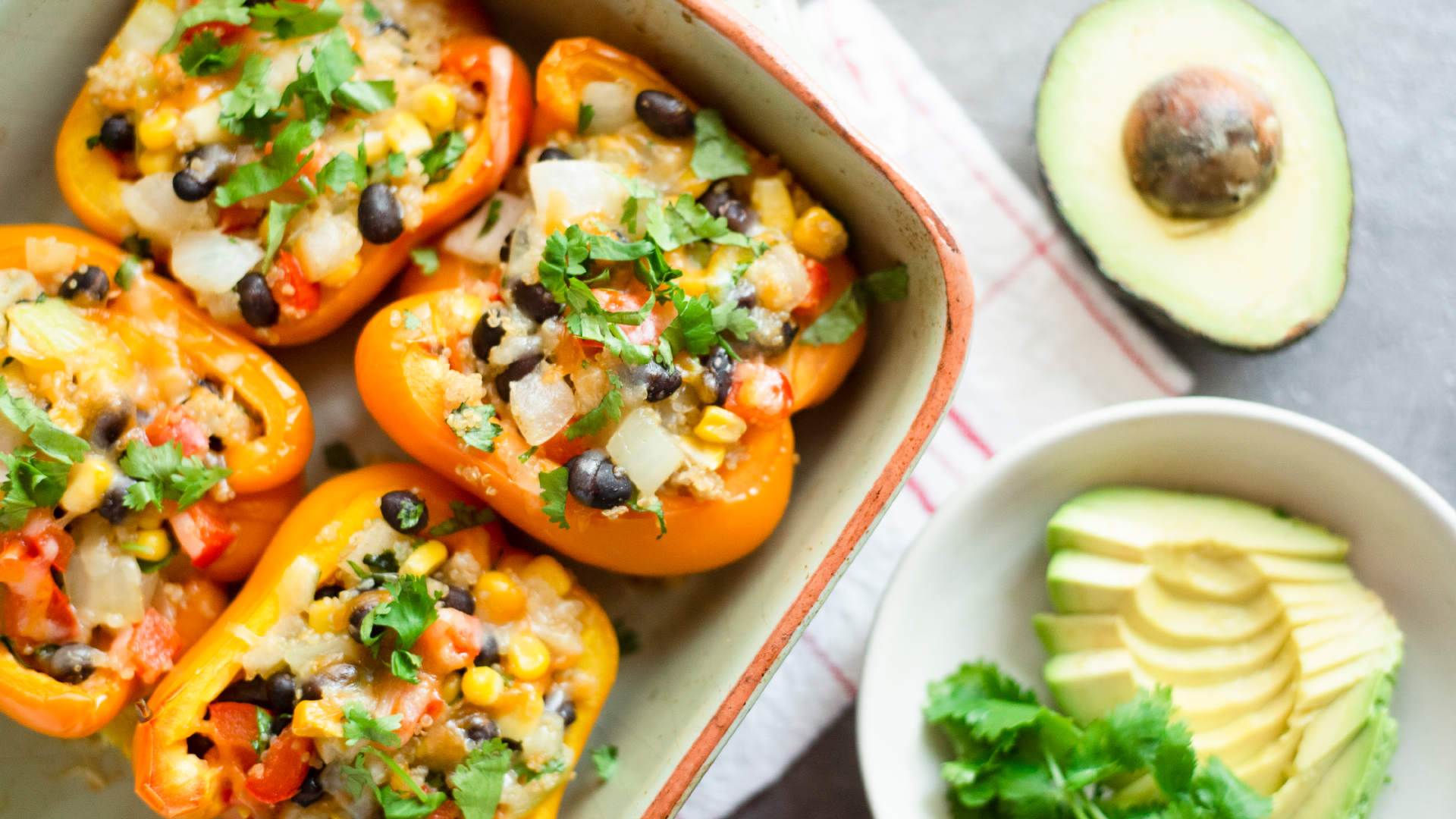 Mexican stuffed peppers with quinoa, beans and corn with avocado on the side.