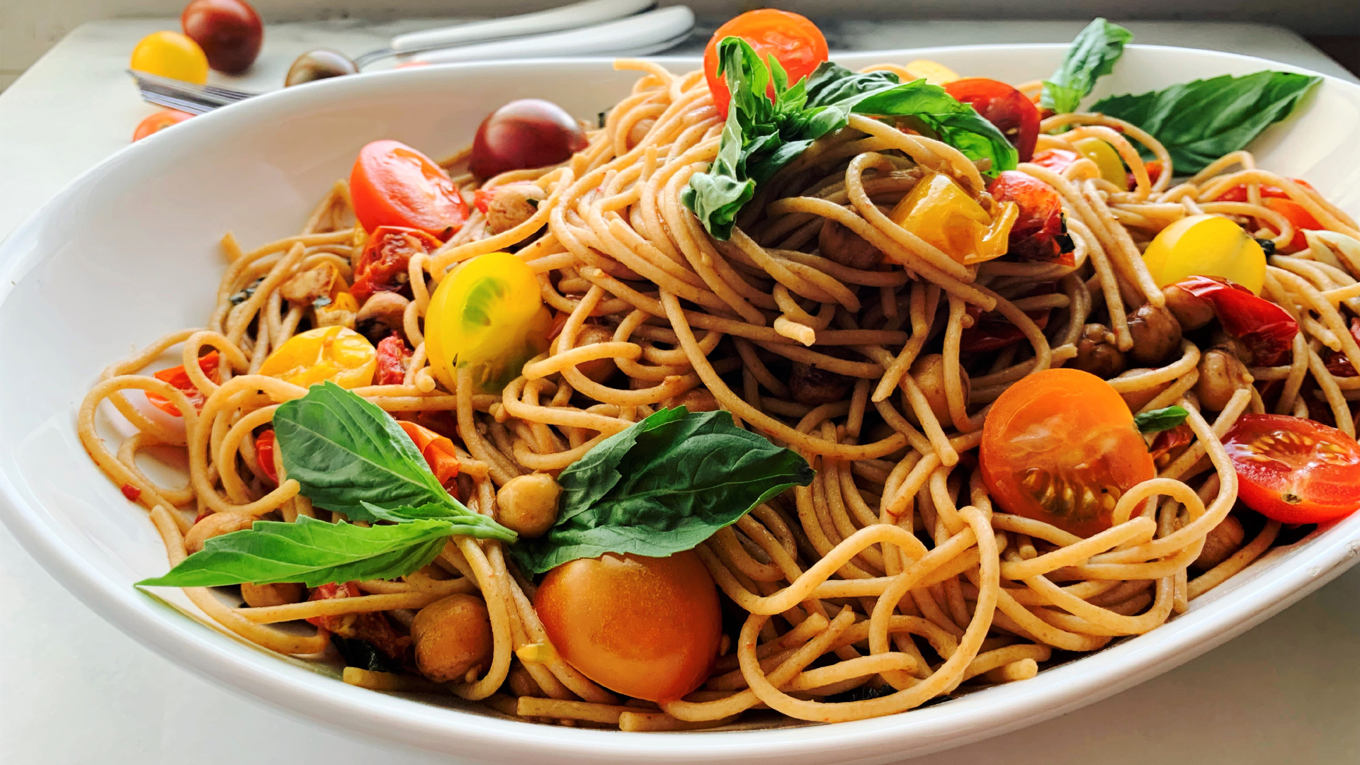 Spaghetti with cherry tomatoes in a white dish