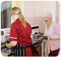 Young and old woman working together to wash and dry the dishes.