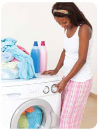 Young woman turning on the laundry machine 