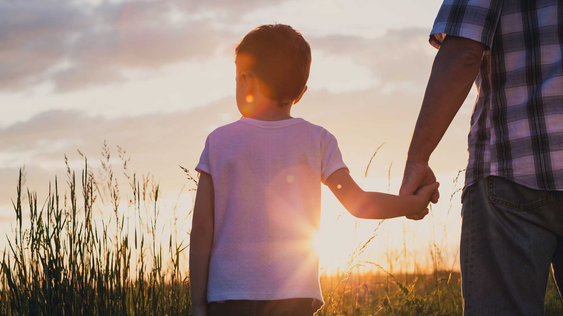 Father and son playing at the park at the sunset time