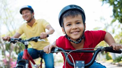 Little boy wearing helmet riding bicycle