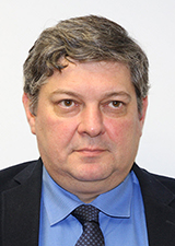 A man wearing a blue shirt and a blue tie. 