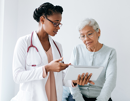 An elderly woman speaks with her doctor