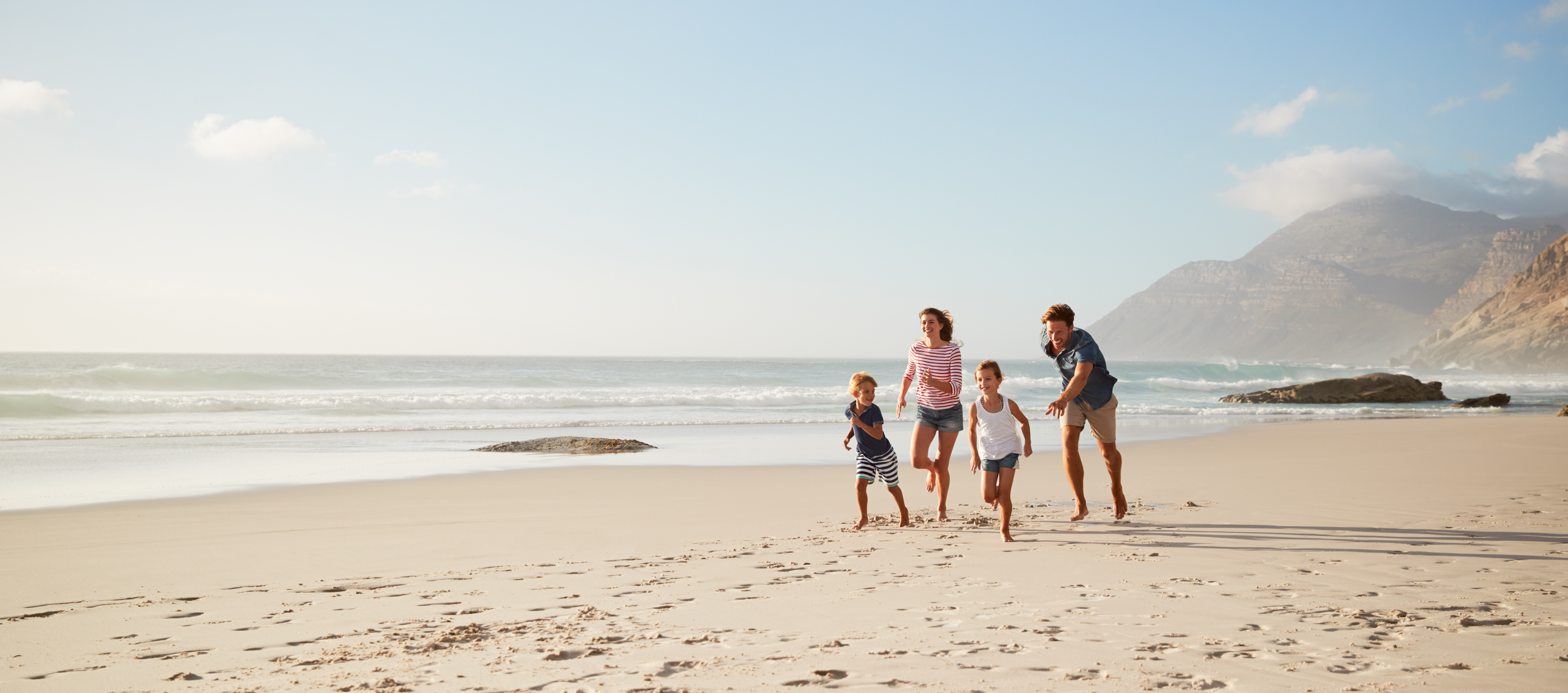 a family running on a beach