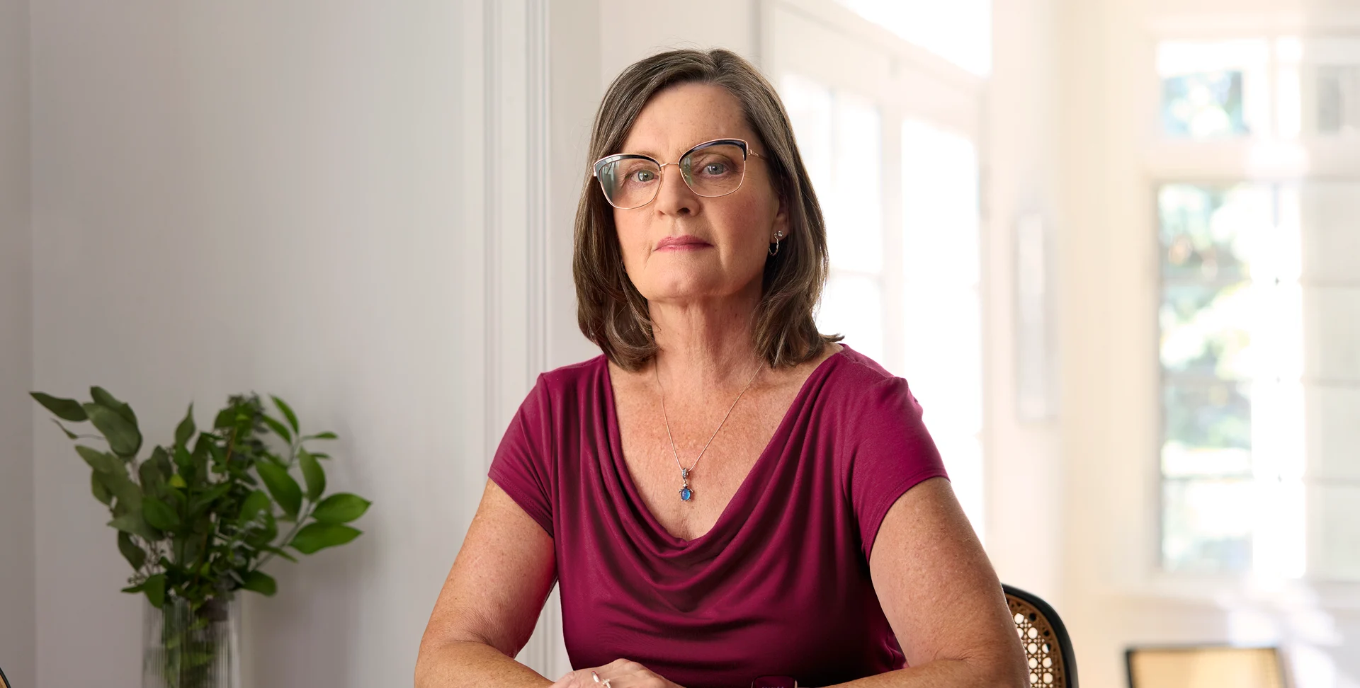 Sharon McVicar sitting at a table, wearing a red shirt.