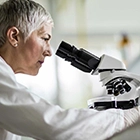 Person looking through a microscope in a lab.