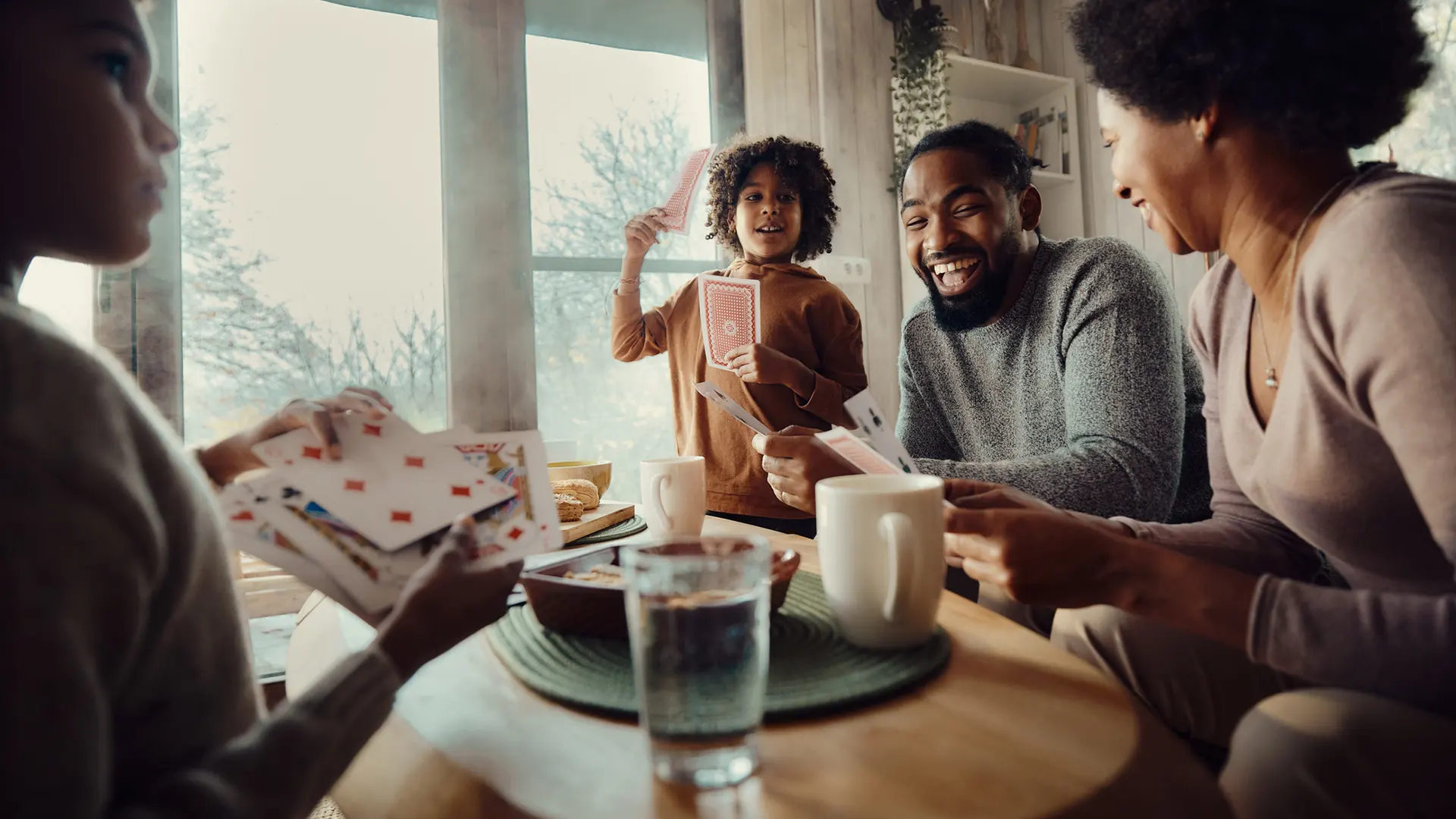 A family playing cards together around a table. 