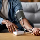 A person checking their blood pressure on their upper arm
