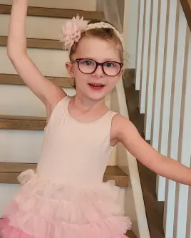 Charlotte at home, dancing on their stairway.