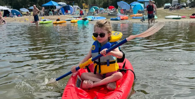 Charlotte paddling across a lake in a kayak.