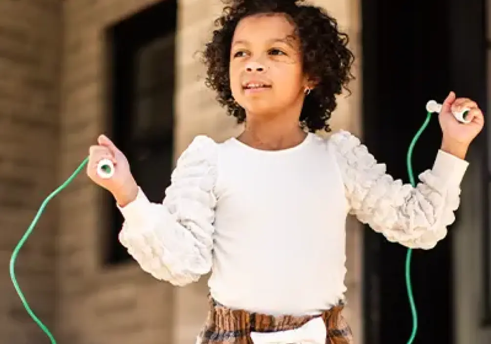 Nora skipping rope by her house.