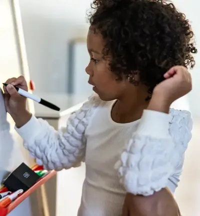 Nora drawing on her whiteboard at home.