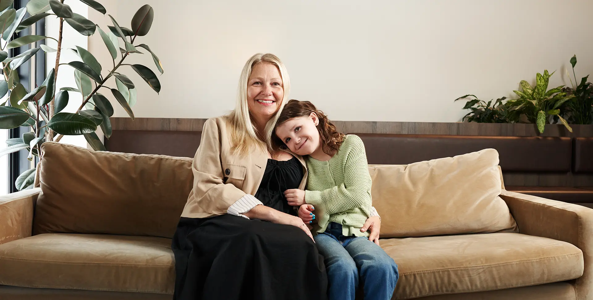 Natalie sitting on the couch snuggling with her mom.