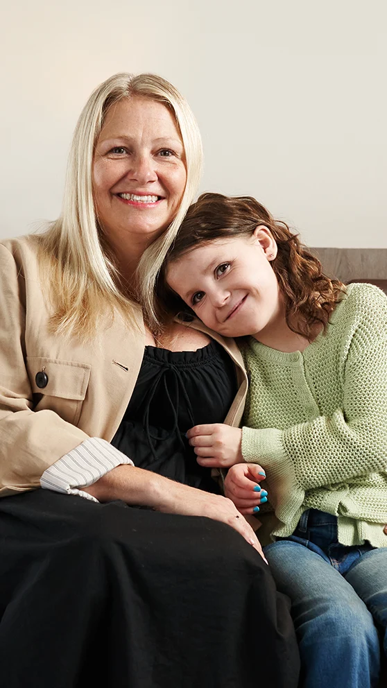 Natalie sitting on the couch snuggling with her mom.
