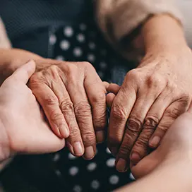 Close-up of two hands gently holding each other