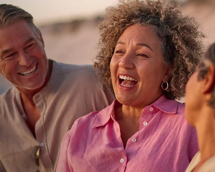 A group of people gathered together, smiling and enjoying each other’s company.