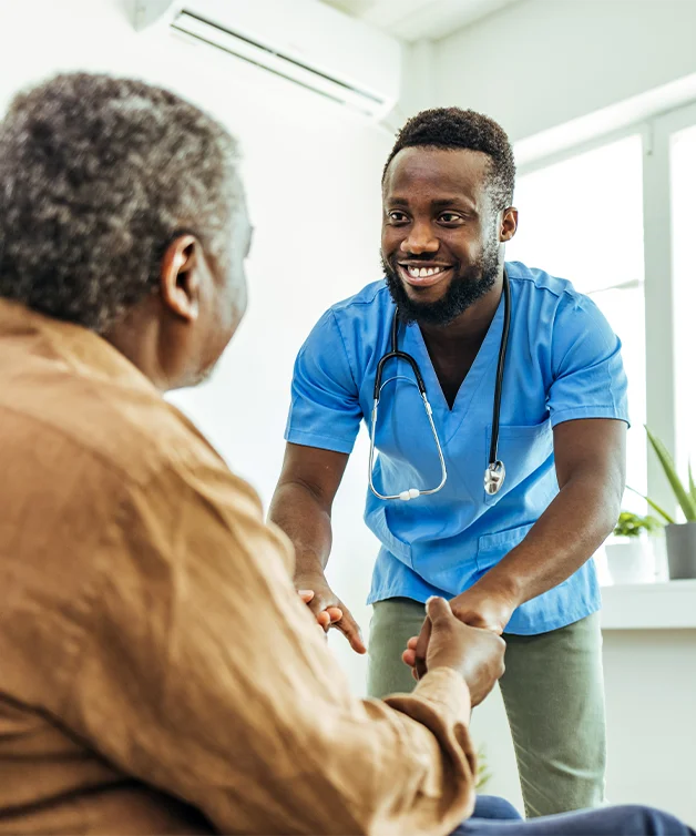 A doctor encouraging a senior man on a wheelchair.