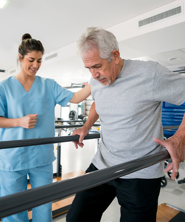 A senior man undergoing stroke rehabilitation, aided by a nurse.