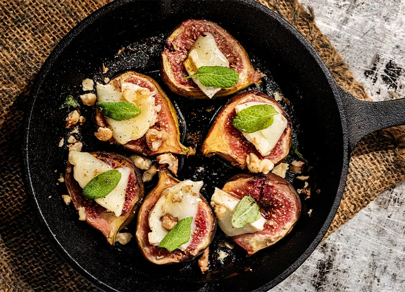 Roasted figs with honey in a skillet.