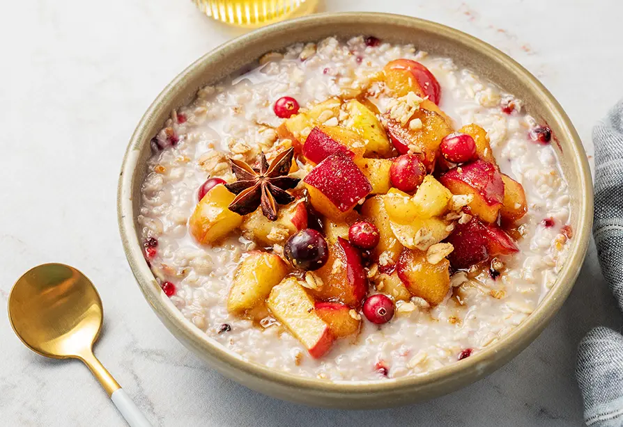 A bowl of couscous cereal with apples, cranberry and cinnamon.