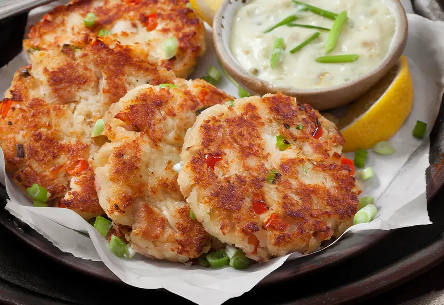 Golden tuna fish cakes on a lined plate.