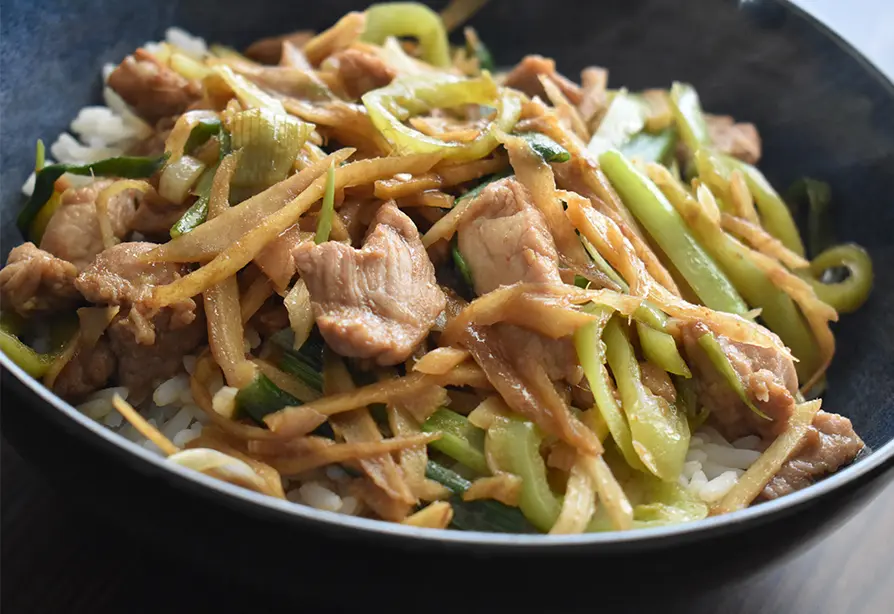 Stir fried pork with pear in a black bowl