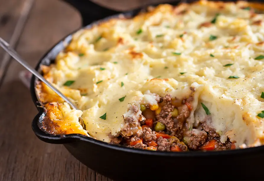 Shepherd’s pie in a cast iron skillet with a spoon