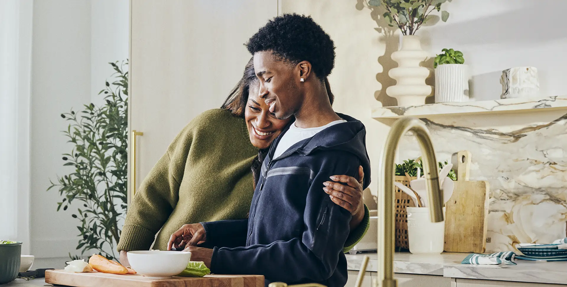 Carissa embraces her son Jayden while cooking together in a kitchen