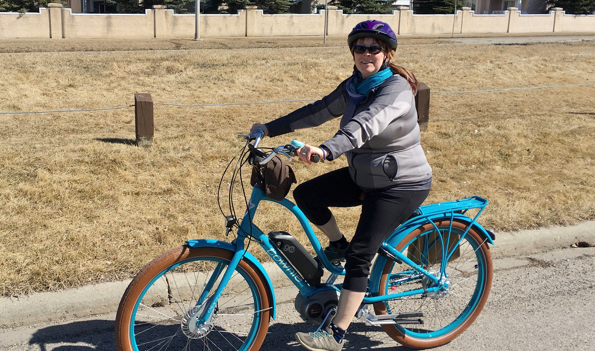 Christina smiles while riding a bike