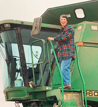Carol Clayton stands on a combine harvester