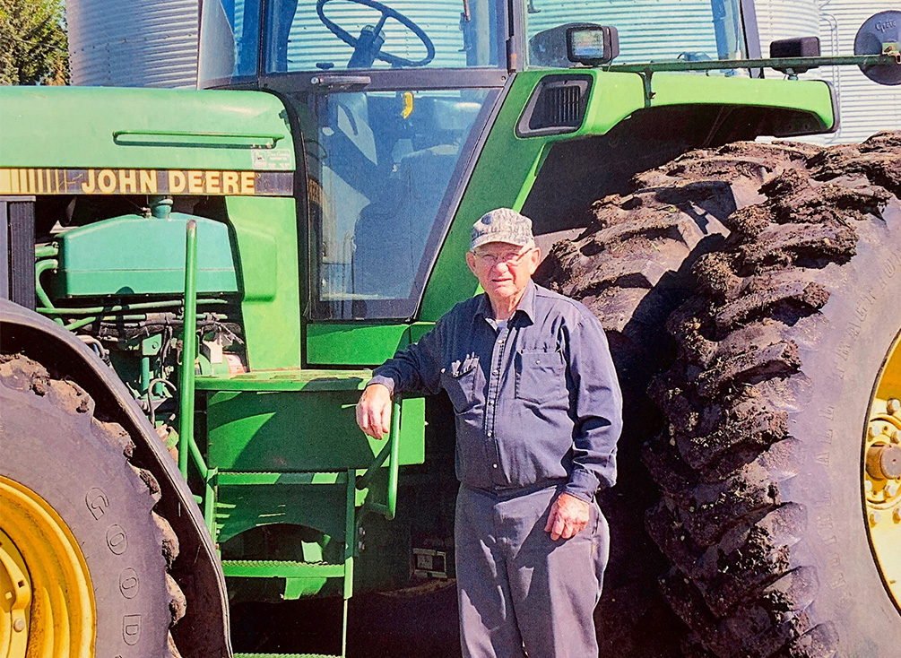 Barrie Clayton stands next to a tractor