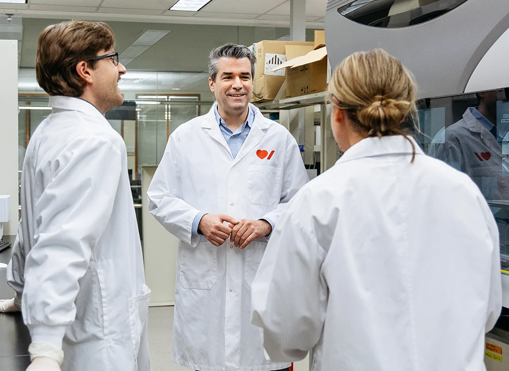 Dr. Guillaume Paré talking to his research team in the lab.