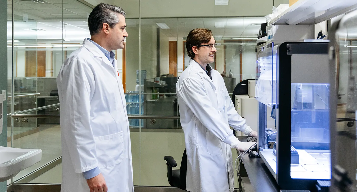 Dr. Guillaume Paré talking to his research assistant in the lab.