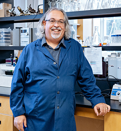 Dr. Glen Pyle smiles in his research lab