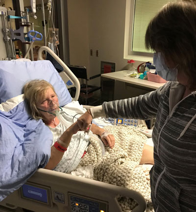 Heather giving her sister Barbara a fist bump after her open heart surgery