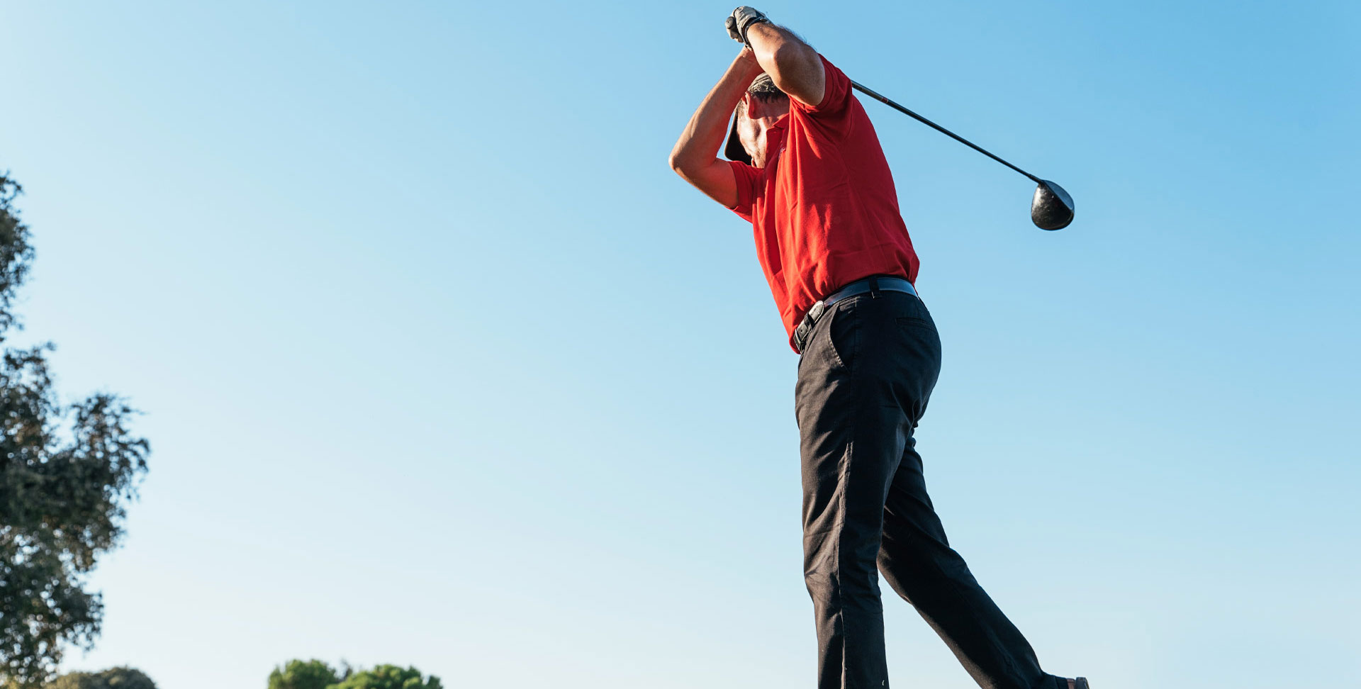 An older man prepares to swing a golf club.