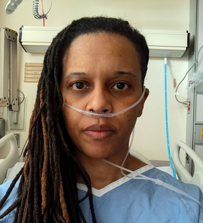 Katherine Isaac in a hospital gown with an oxygen tube.