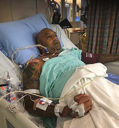 Kevin at the hospital bed undergoing emergency care.