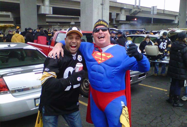 Kevin poses for a photo next to a man in a Superman costume