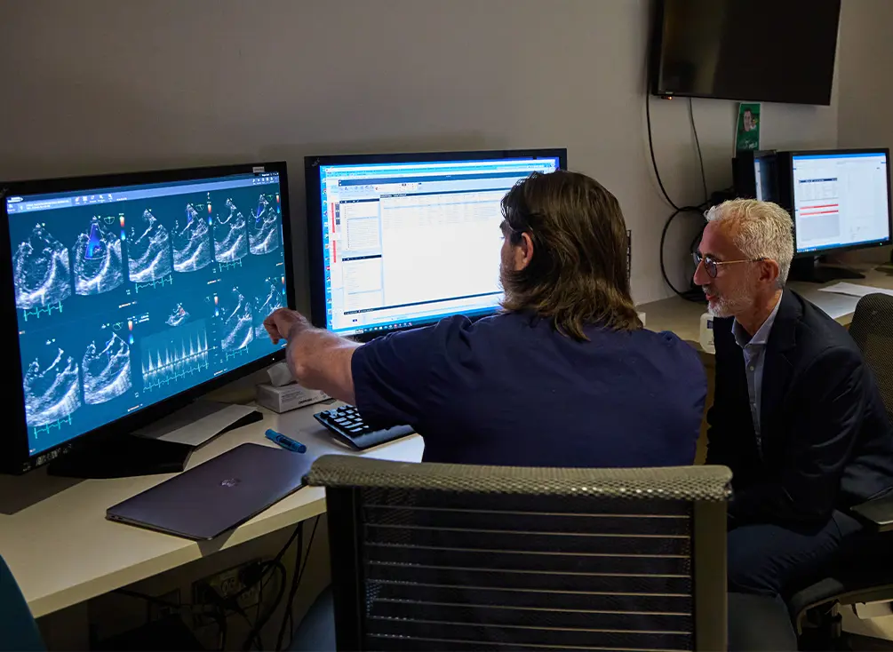 Dr. Luc Mertens and his research assistant studying their computers.