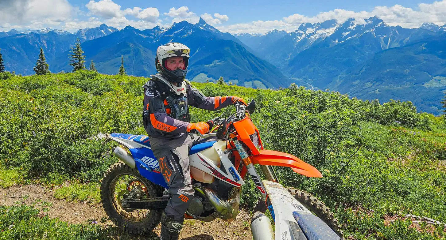Mark riding a dirt bike on a scenic trail.