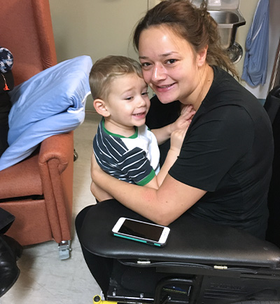 Megan sits on a wheelchair at the hospital with her son, Lucas. 
