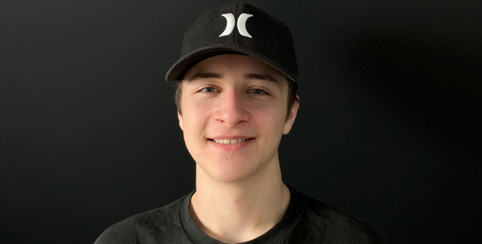 Olivier Lanthier smiles in a dark top and baseball cap