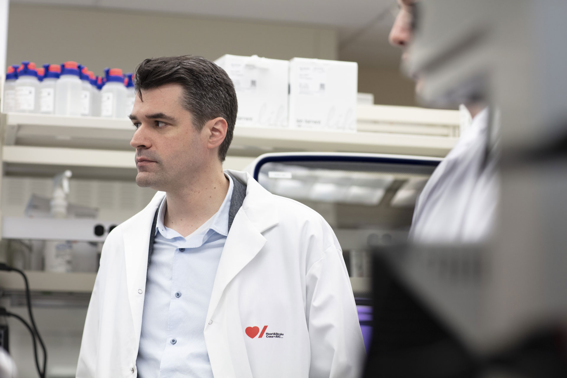Dr. Pare in a white lab coat with the Heart & Stroke logo on it