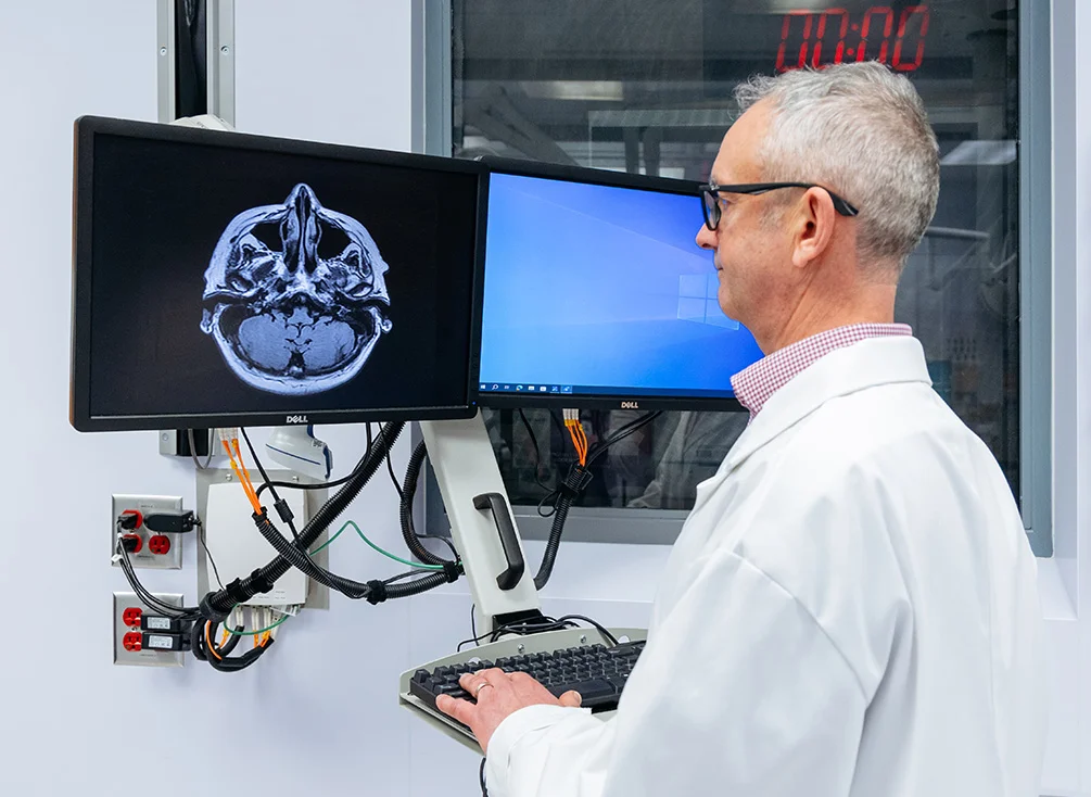 Dr. Philip Barber studying brain scans on a computer at his lab.