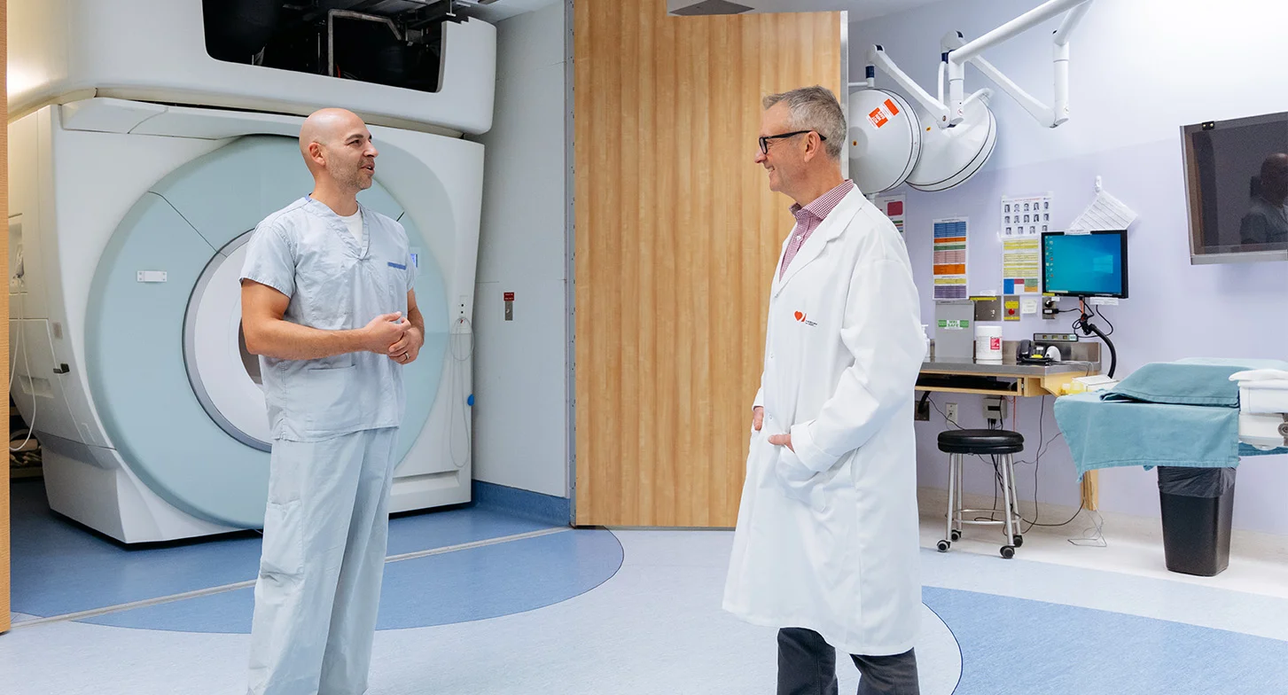 Dr. Philip Barber speaking with his colleague near an MRI machine
