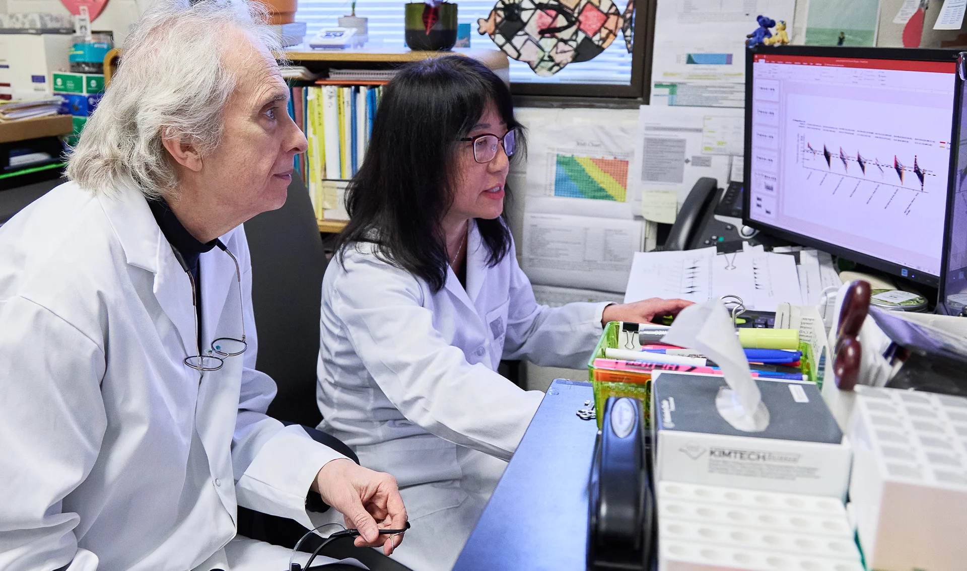Heart & Stroke researcher Dr. Robert Hegele and his research assistant studying data in a computer at their lab.