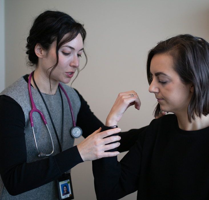 Doctor Field assessing the range of motion on a patient’s arm.